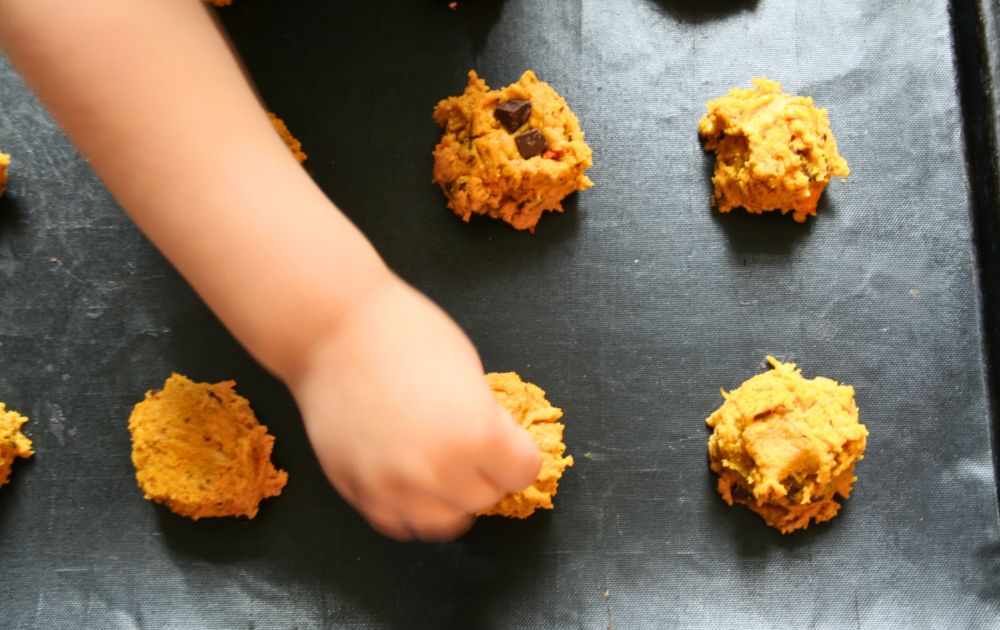 Kind steckt Schokoladen Stücke in Kekse